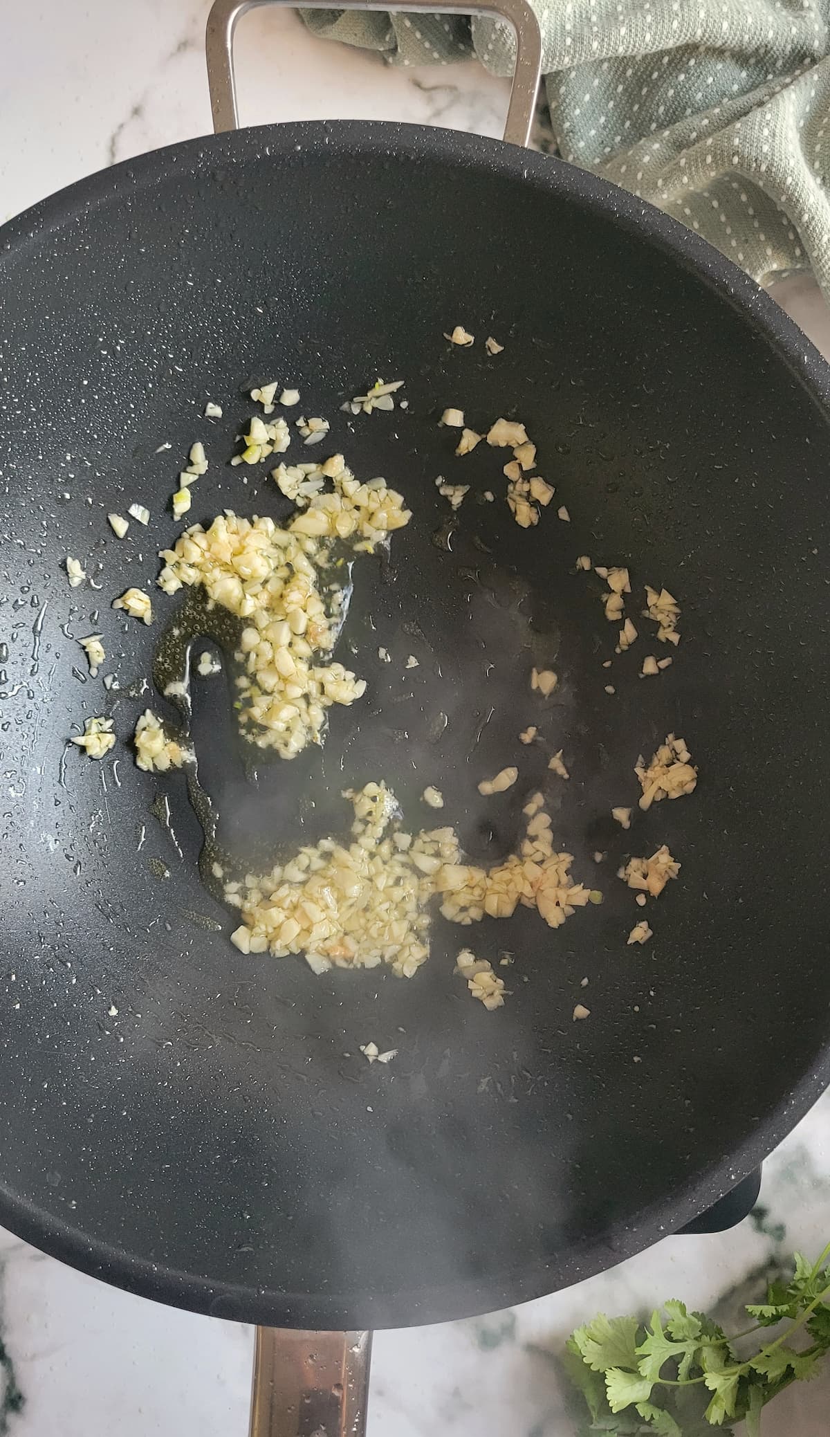 minced garlic cooking in oil in a wok