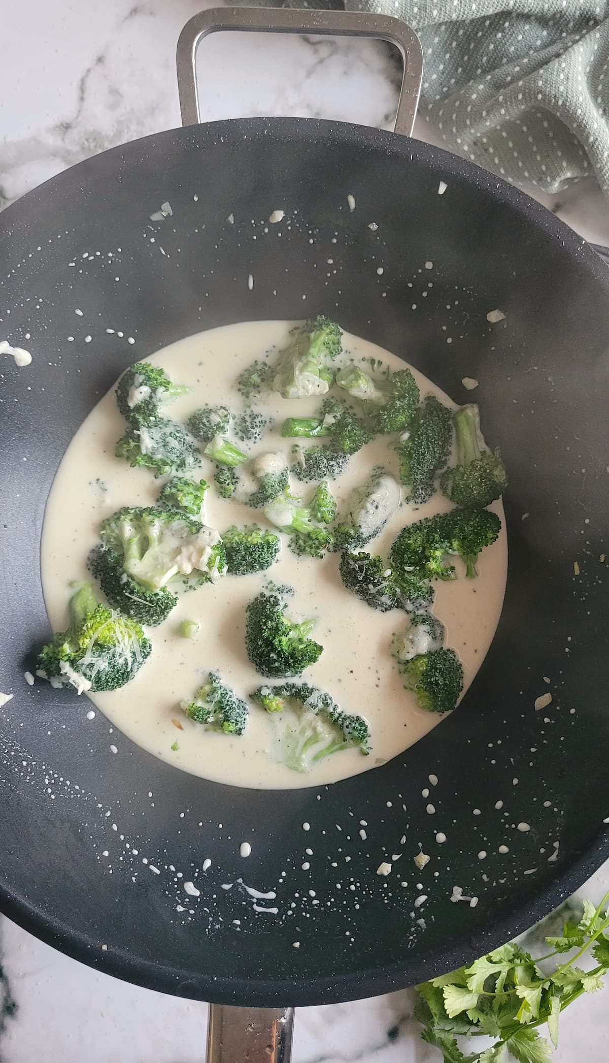 broccoli florets in a creamy sauce in a wok
