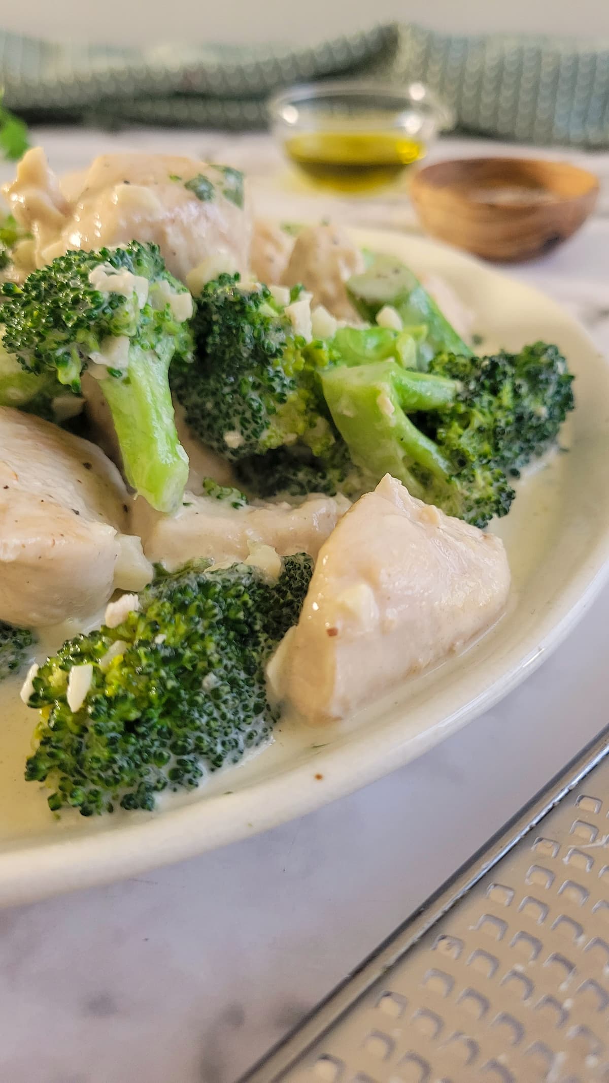 side view of a plate of chicken and broccoli in alfredo sauce