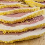 slices of raw peameal bacon on a cutting board