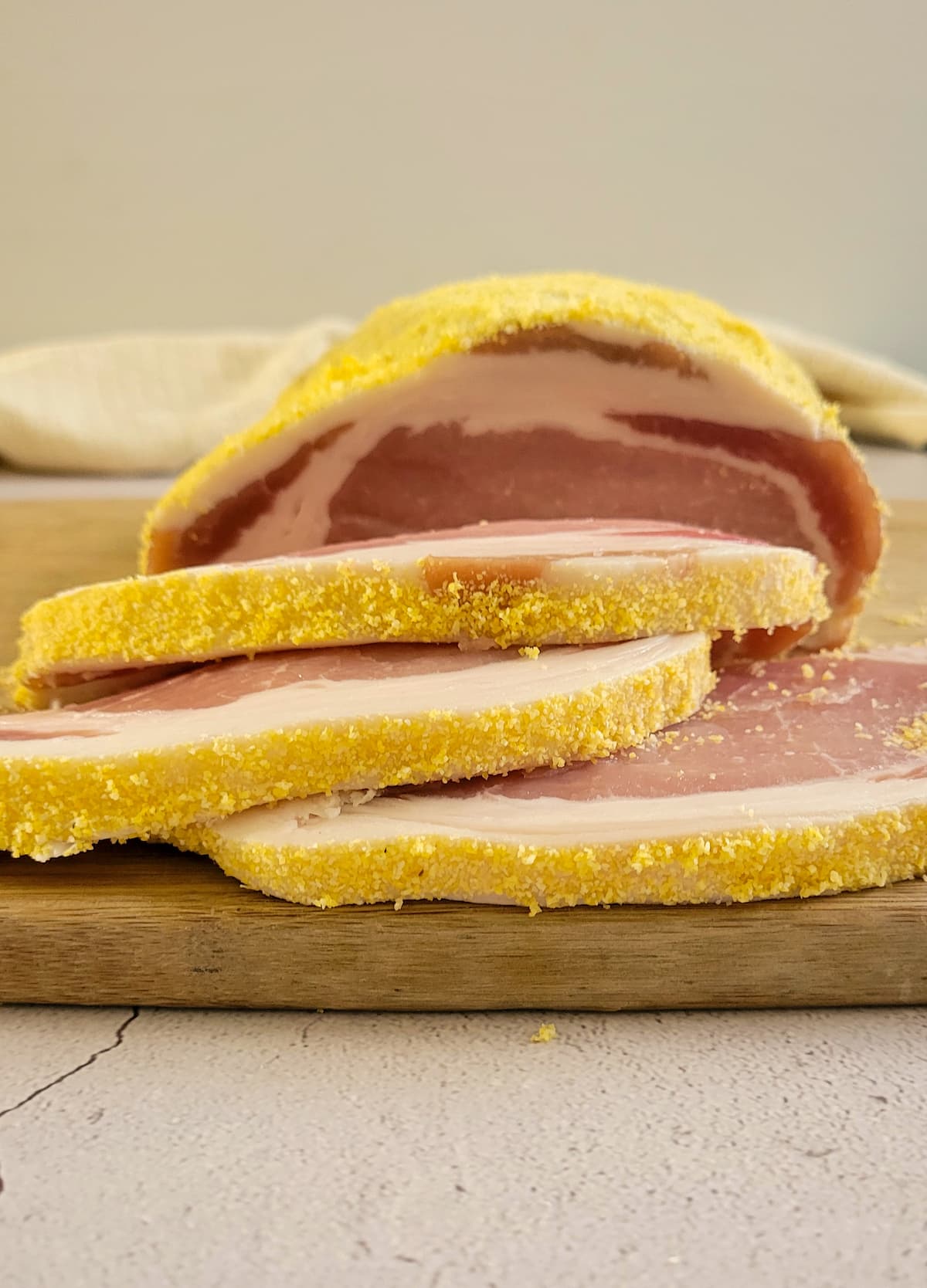 peameal bacon slices and whole loin on a cutting board