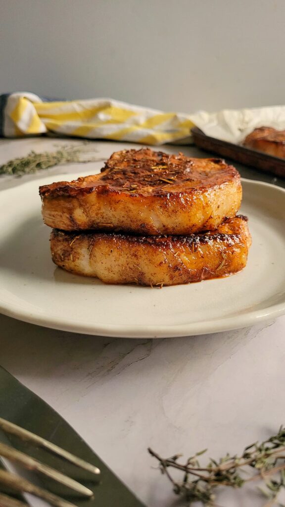 2 cooked pork chops stacked on a plate