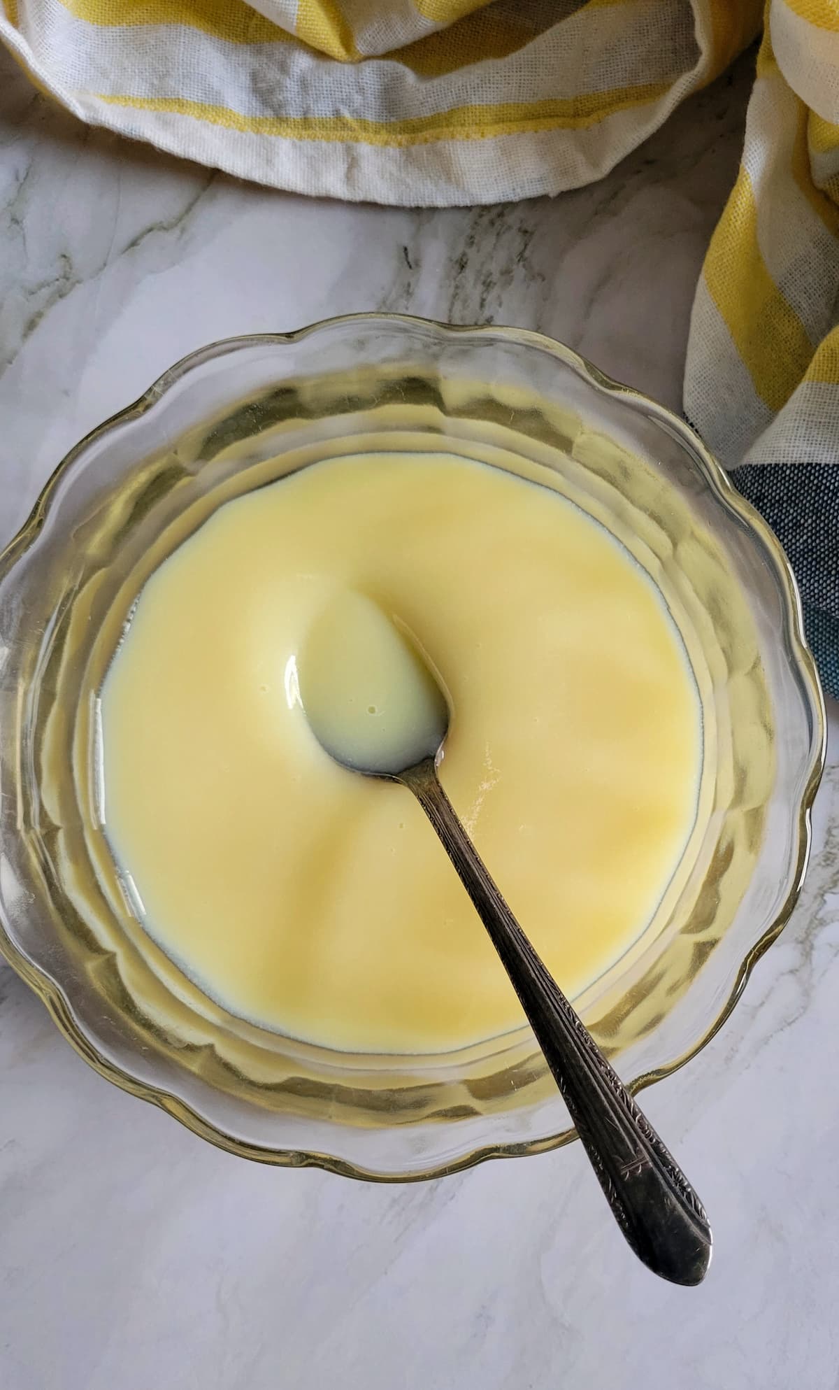 bowl of condensed milk with a spoon in it