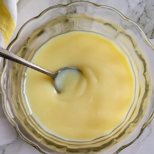 bowl of condensed milk with a spoon in it