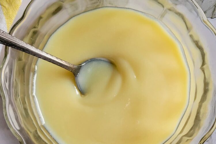 bowl of condensed milk with a spoon in it