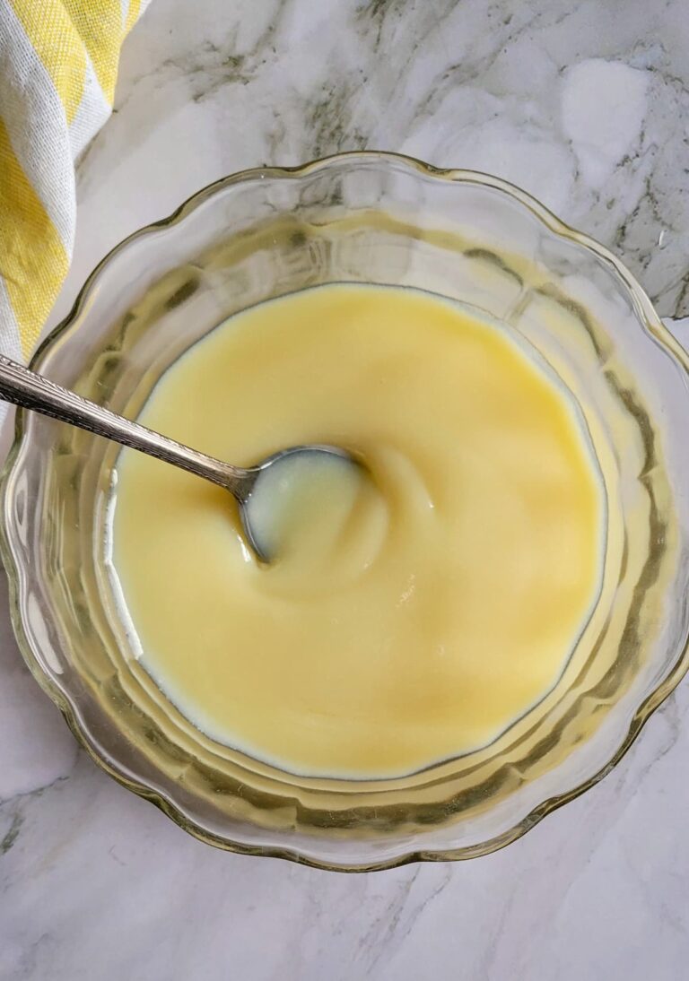 bowl of condensed milk with a spoon in it