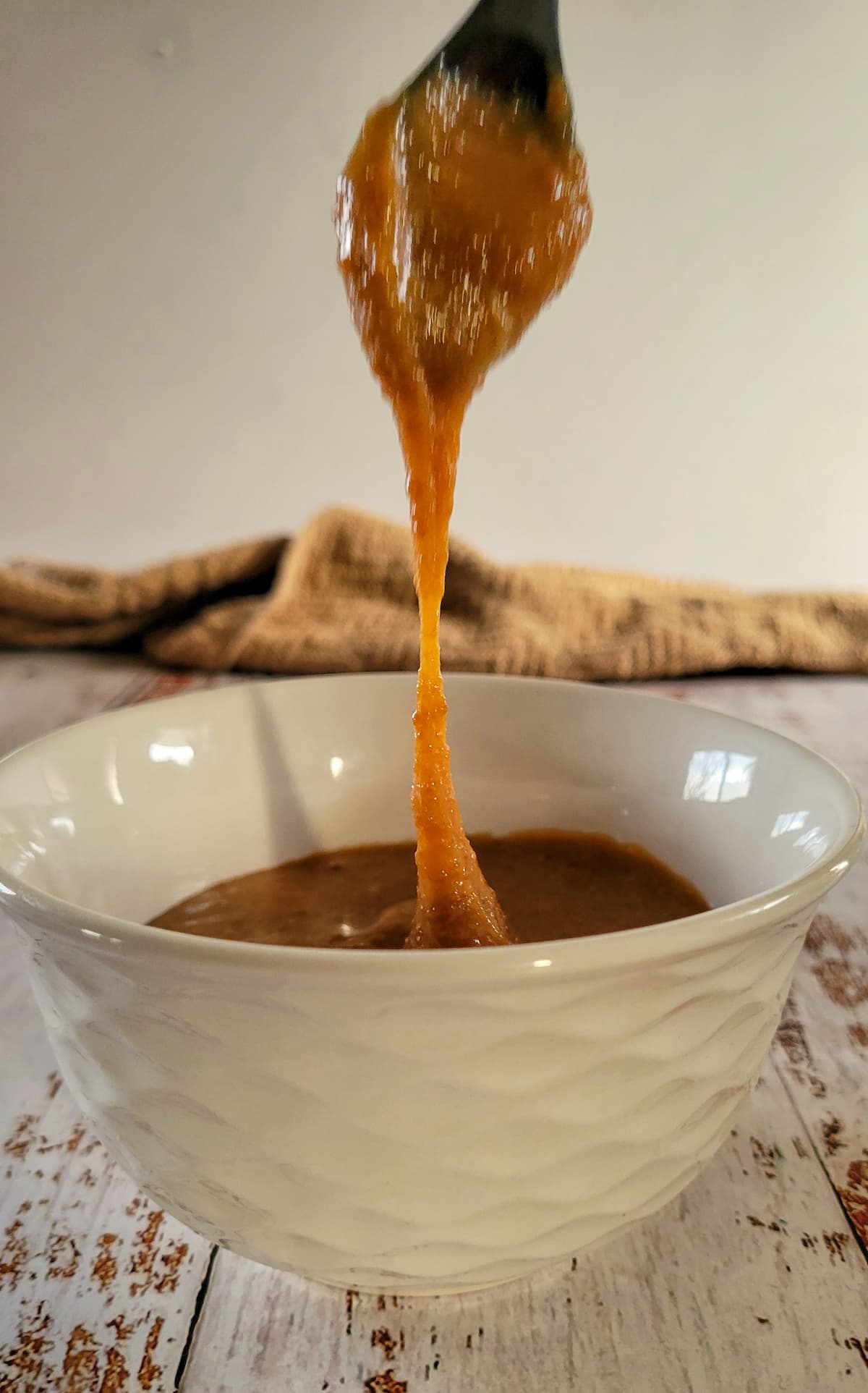 caramel sauce dripping into a bowl