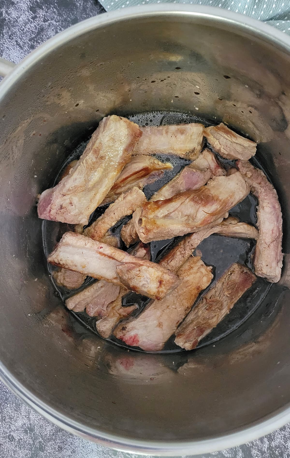single ribs in a dark sauce in a pot