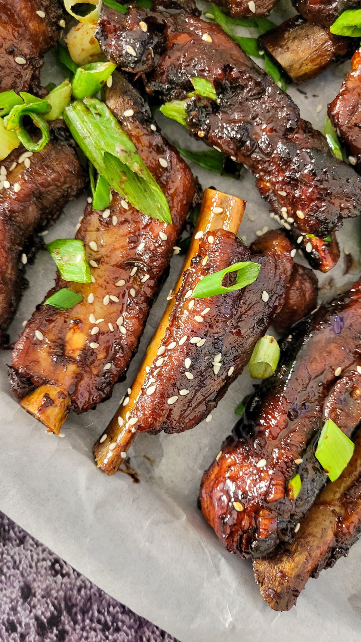 ribs with green onions and sesame seeds on a piece of parchment