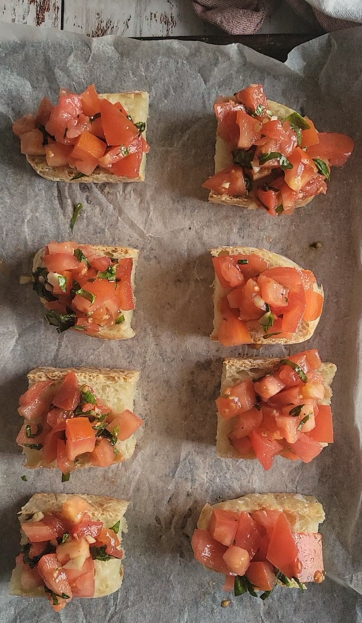 slices of bruschetta on a parchment lined baking sheet
