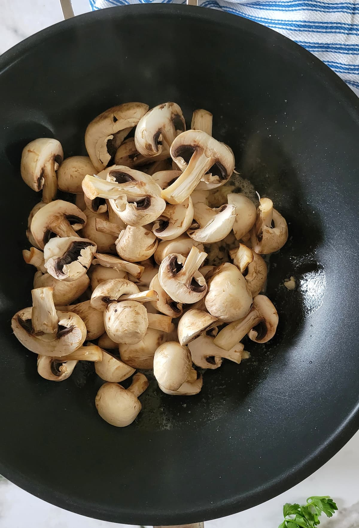 halved raw mushrooms in a wok