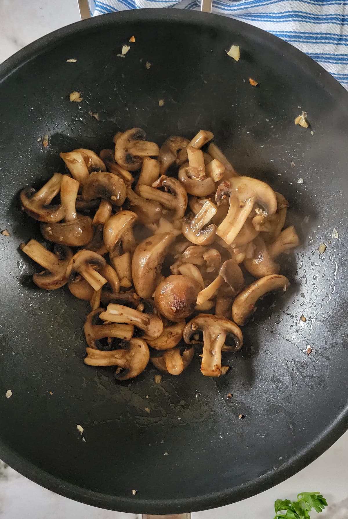mushrooms cooking in a skillet with garlic