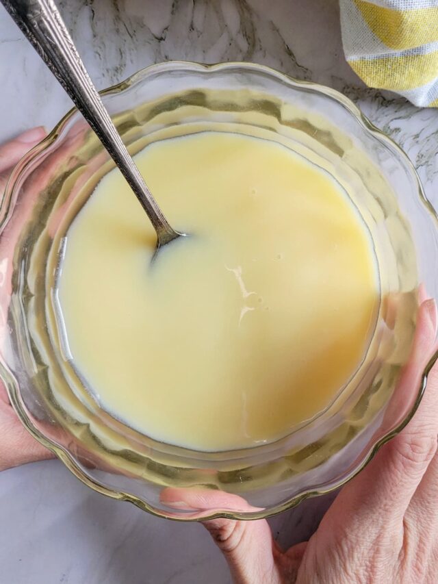 hands holding a bowl of condensed milk with a spoon in it