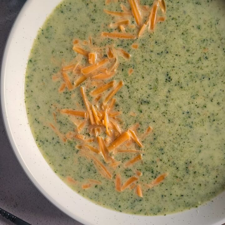 broccoli & cheese soup next to some broccoli florets