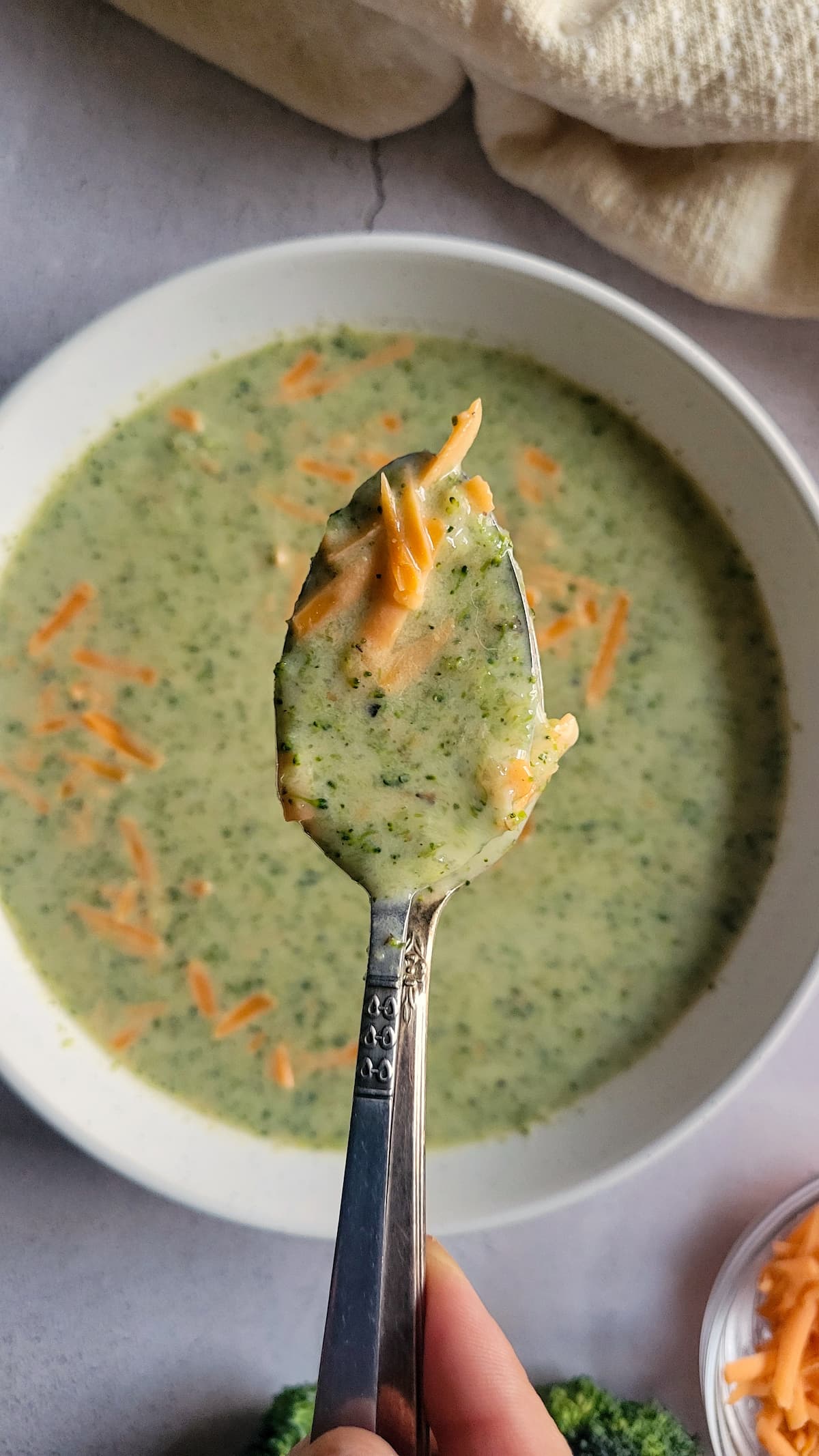 spoonful of broccoli and cheese soup over a bowl of the rest of it
