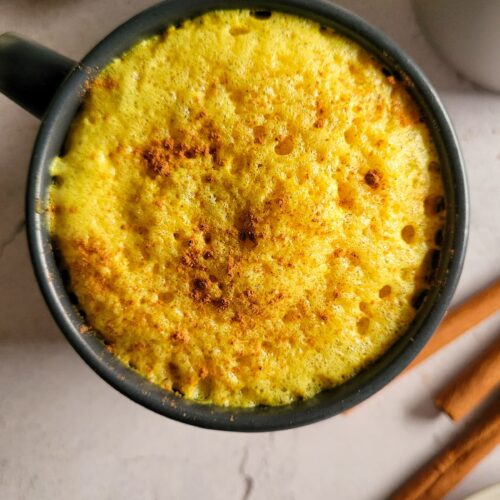 turmeric latte in a mug topped with cinnamon