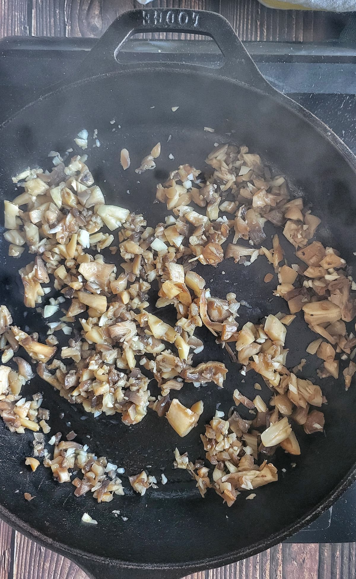 chopped mushrooms and garlic sauteeing in a cast iron skillet