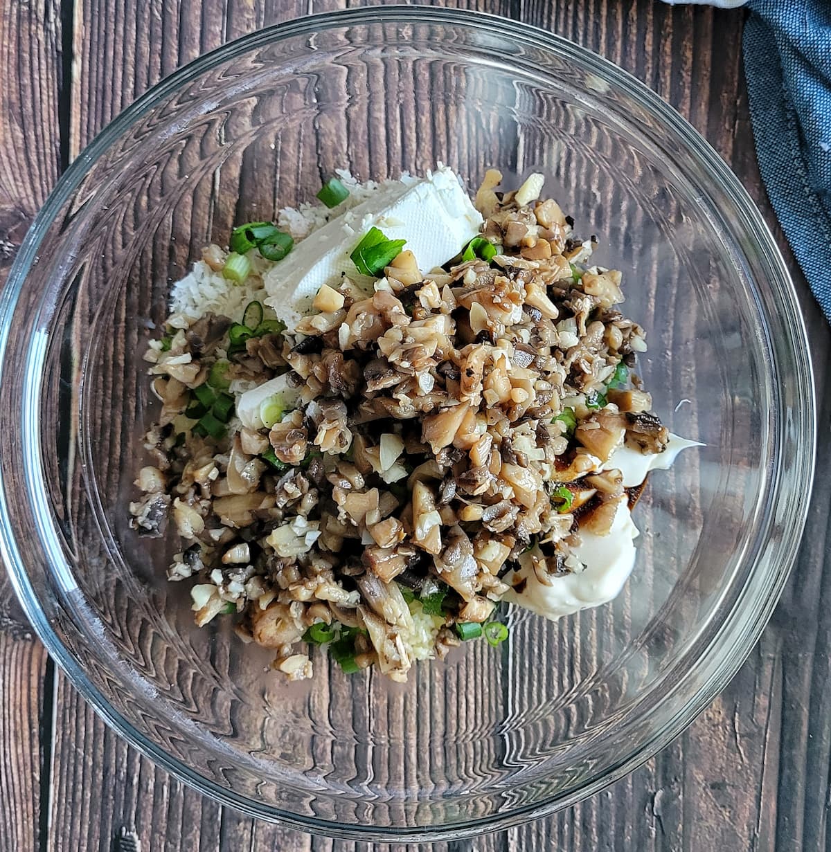 chopped mushrooms, green onions, cream cheese and other ingredients unmixed in a bowl