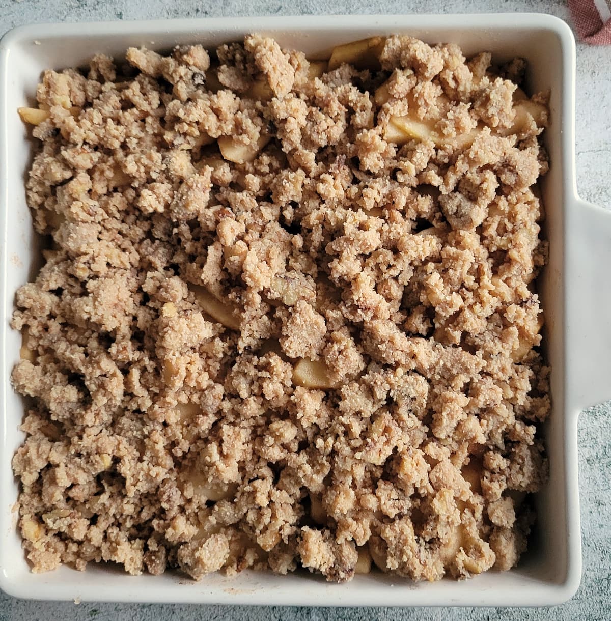 apple crisp with a crumbly topping in a baking dish