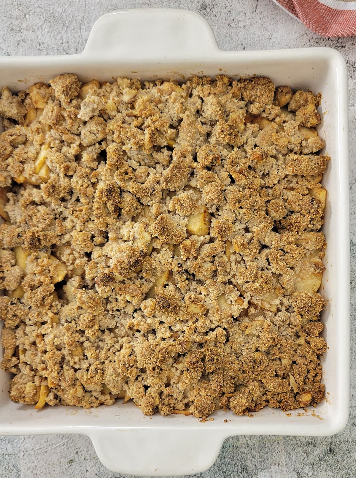 baked and golden apple crisp in a square baking dish
