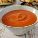 bowl of red sauce, crispy wings in the background