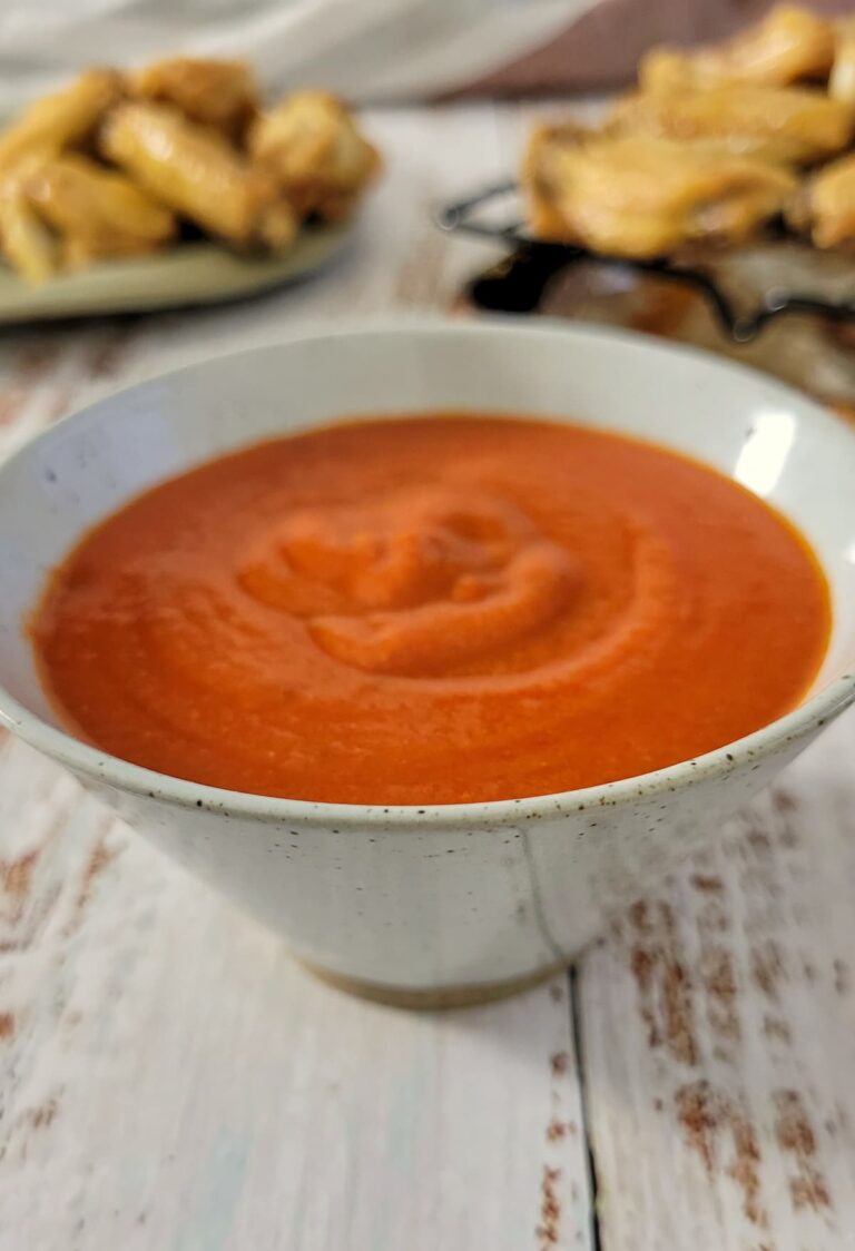 bowl of red sauce, crispy wings in the background