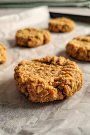 peanut butter oatmeal cookies on a parchment lined baking sheet