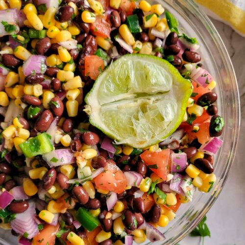 black bean and corn salsa in a bowl with a squeezed lime