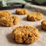 6 peanut butter oatmeal cookies on a parchment lined baking sheet