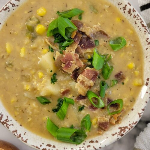 bowl of potato and corn soup with chopped green onions and bacon
