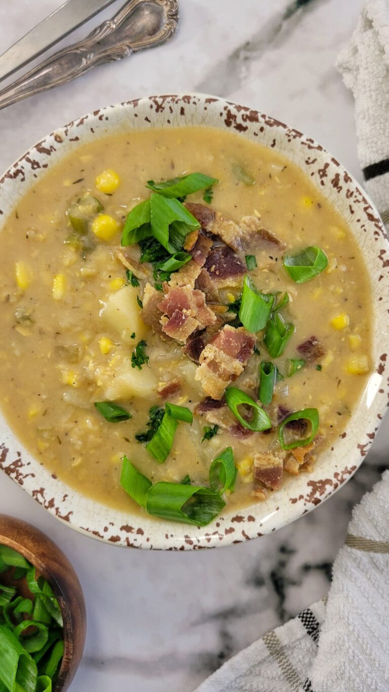 bowl of potato and corn soup with chopped green onions and bacon
