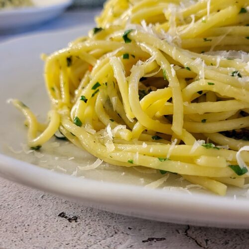 pasta aglio e olio on a plate, more in the background