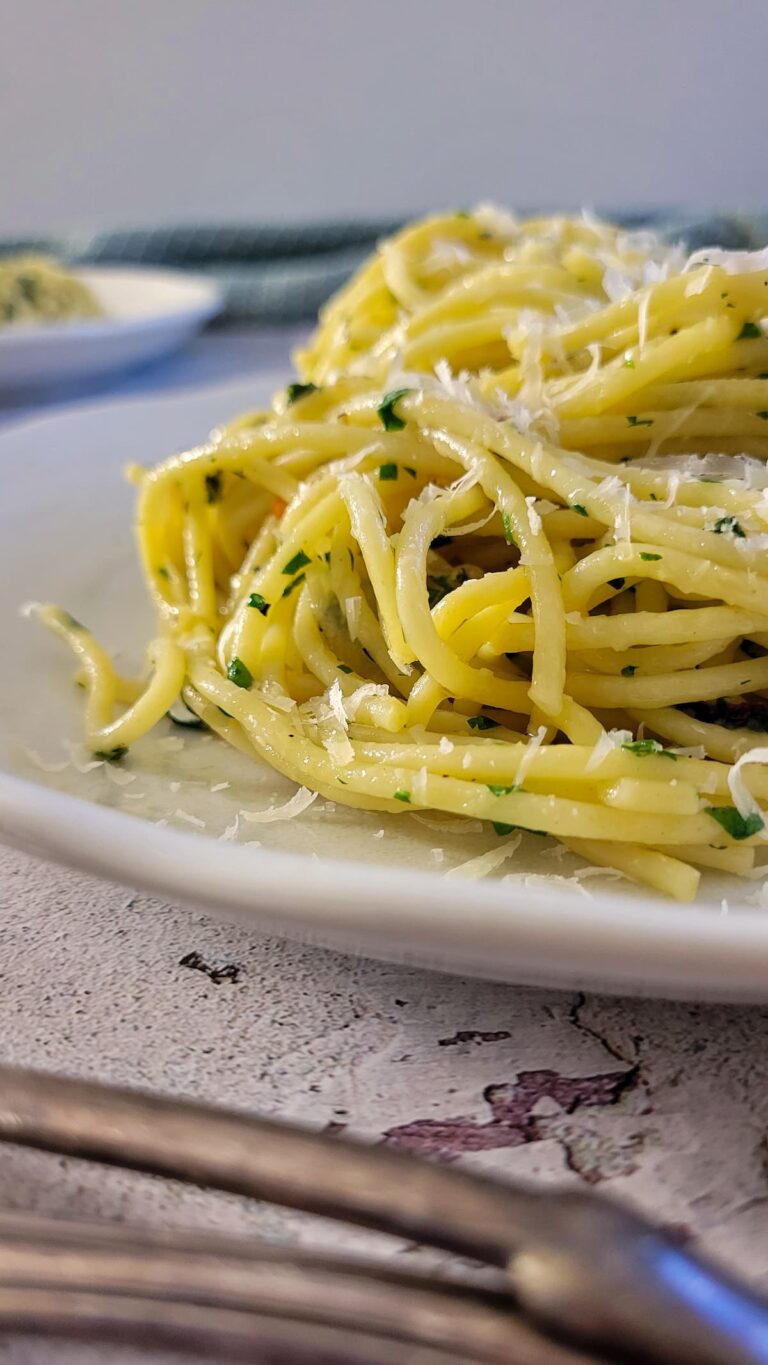 pasta aglio e olio on a plate, more in the background