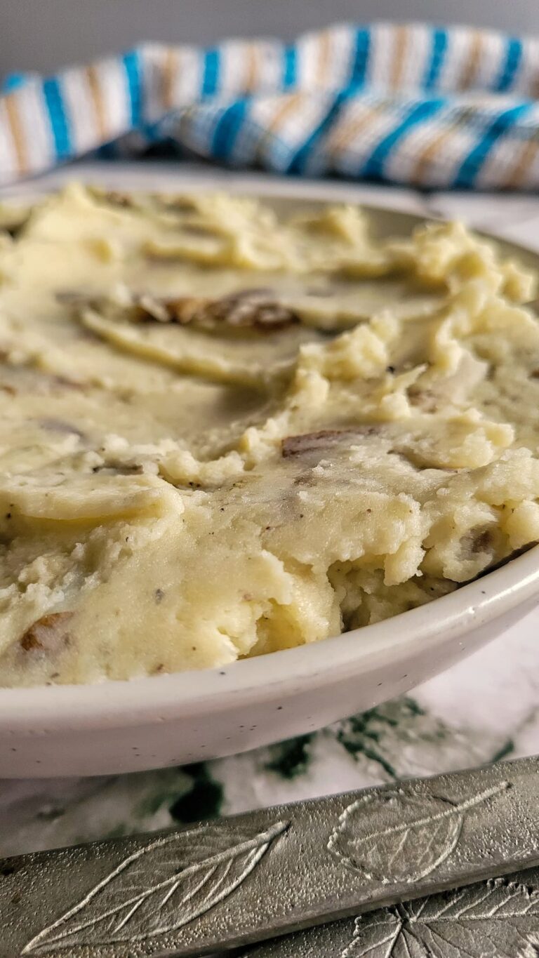 side view of a bowl mashed potatoes with a spoon in it