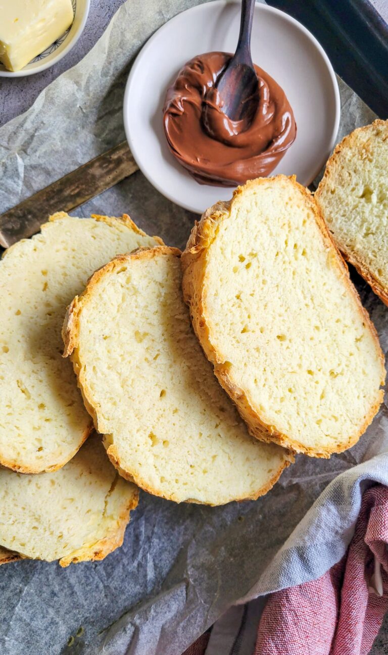 slices of irish soda bread on a parchment lined baking sheet next to some nutella on a plate with a spoon