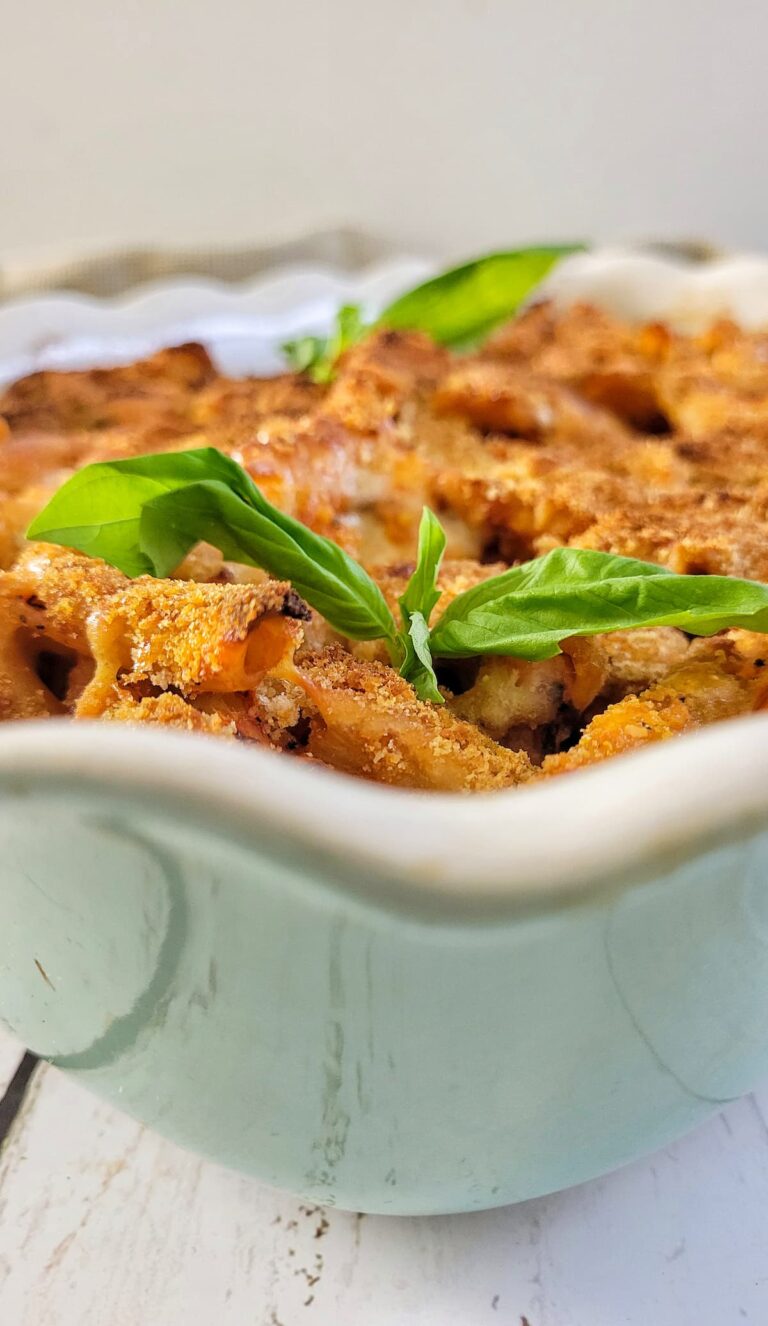 casserole dish with penne pasta in tomato sauce with fresh basil