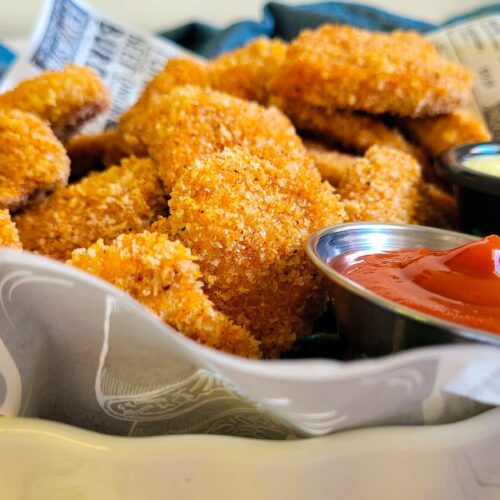 chicken nuggets in a lined dish with ketchup on the side
