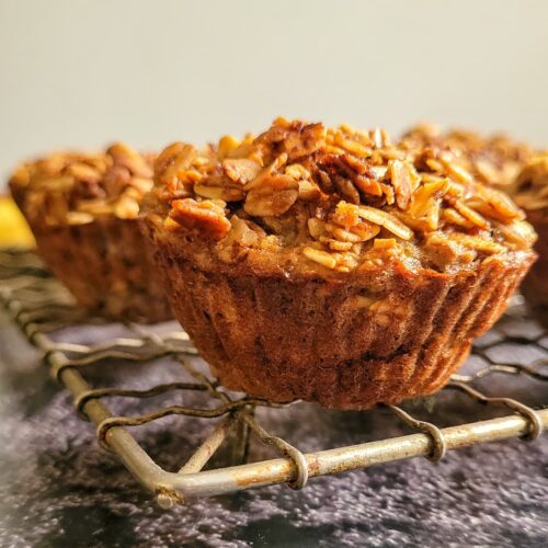 muffins topped with oats on a wire rack