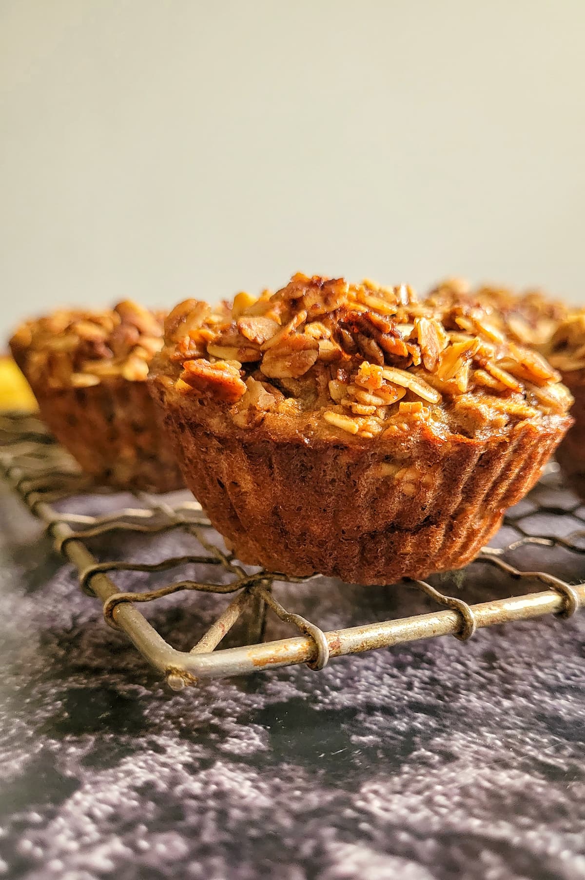 muffins topped with oats on a wire rack