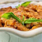 casserole dish with penne pasta in tomato sauce with fresh basil