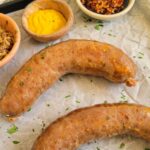 baked italian sausages on a tray with sauces