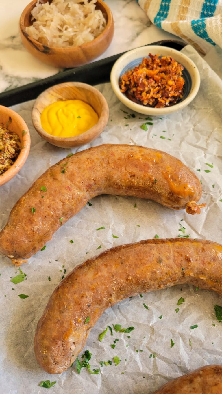 baked italian sausages on a tray with sauces
