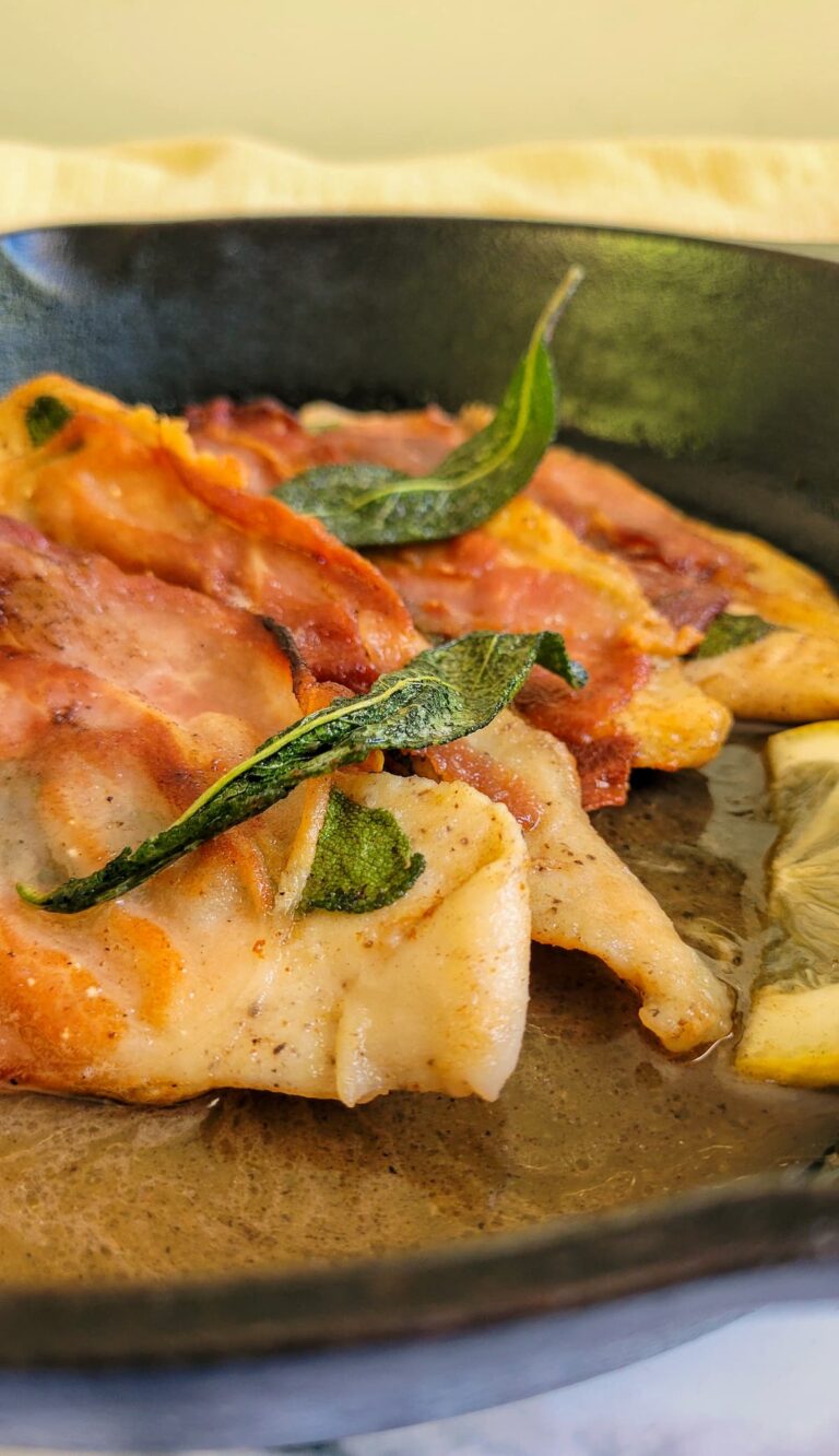 chicken saltimbocca in a cast iron skillet with lemon and fried sage