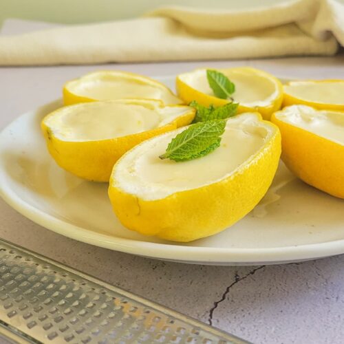 side view of lemon posset garnished with fresh mint on a plate