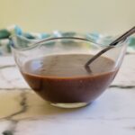 brown thick sauce in a bowl with a spoon