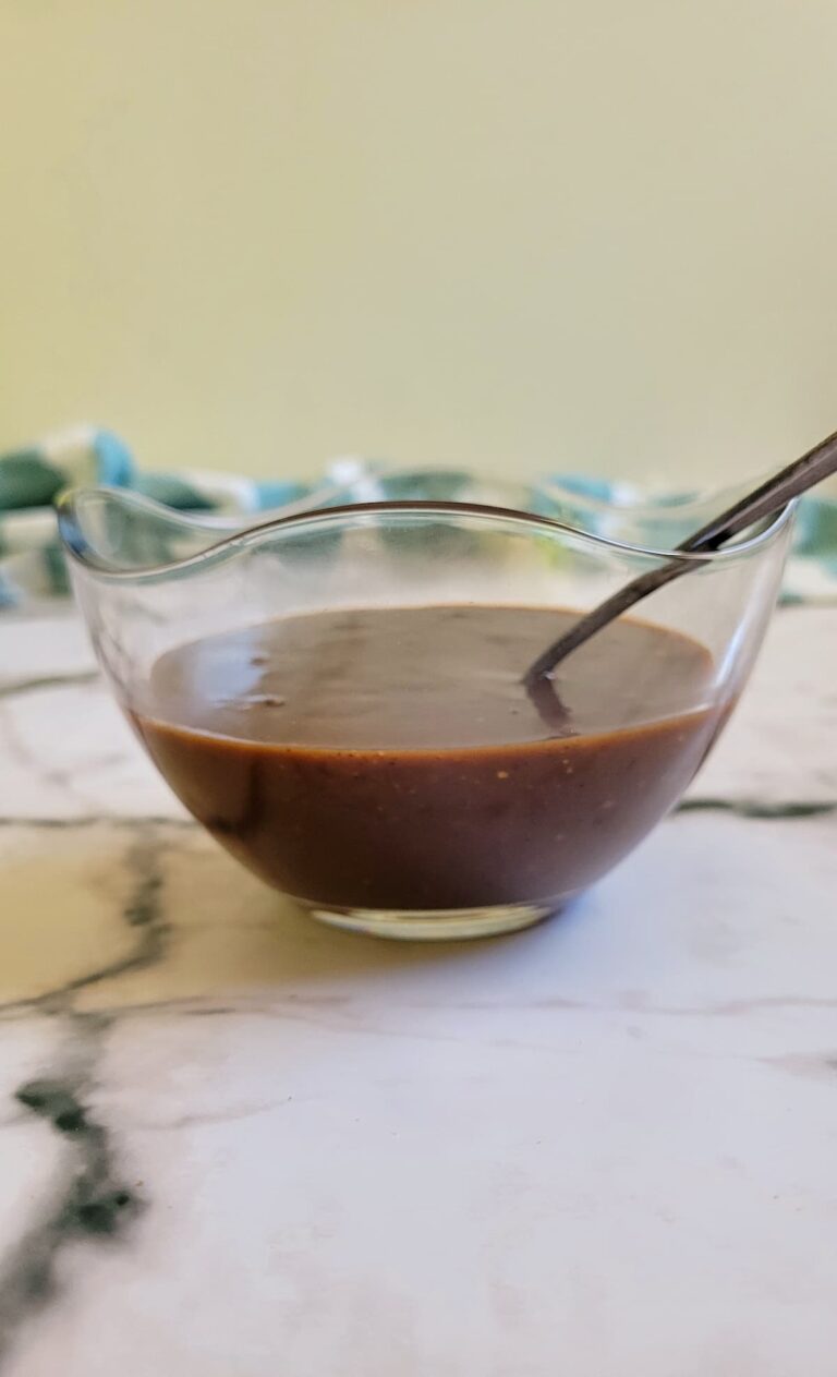 brown thick sauce in a bowl with a spoon