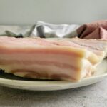 slab of raw pork belly on a plate