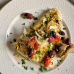 plate of halibut with kalamata olives, sun-dried tomatoes, onions, artichokes, parsley, lemon