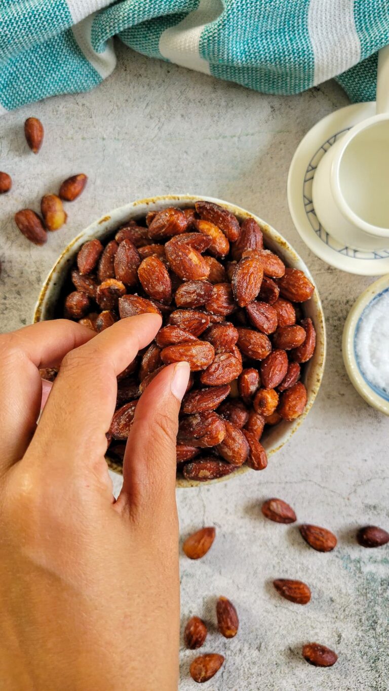 hand picking out some almonds from a bowl