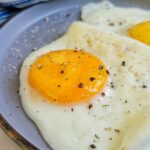 sunnyside up eggs on a plate with salt and pepper